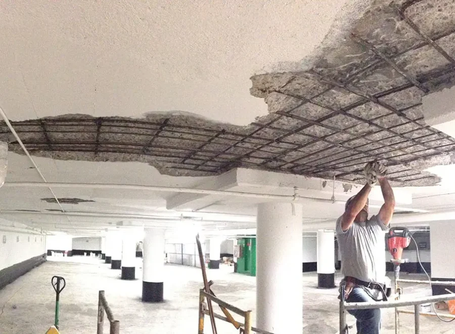 ICC workers removing loose concrete in parking garage ceiling